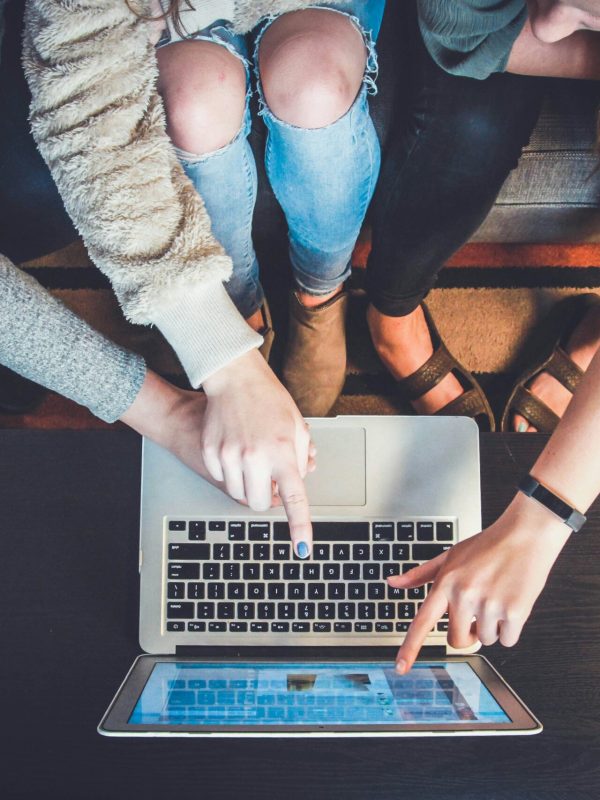 three person pointing the silver laptop computer